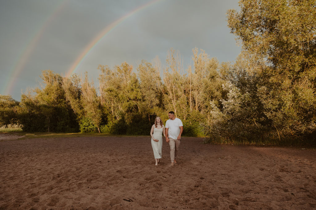 Babybauchfotos in berlin mit der Berliner Fotografin für Kinderfotografie Maria Brussig Lensofbeauty. fotos am See. Fotoshooting Babybauch im grünen. Wasser im Hintergrund. Paarfotos zusammen am See. Regenbogen shooting Regenbogen fotos