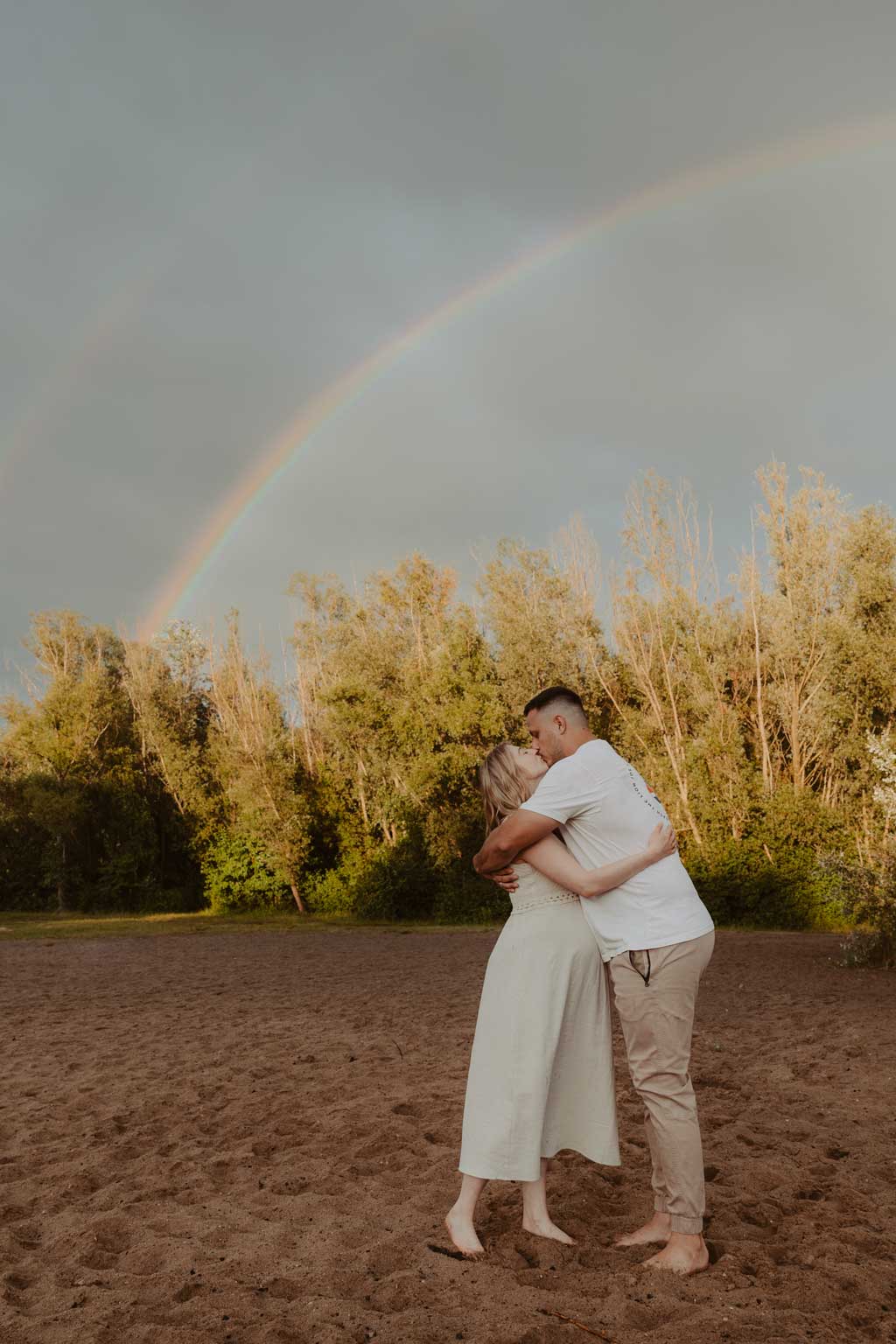 Babybauchfotos in berlin mit der Berliner Fotografin für Kinderfotografie Maria Brussig Lensofbeauty. fotos am See. Fotoshooting Babybauch im grünen. Wasser im Hintergrund. Paarfotos zusammen am See. Regenbogen shooting Regenbogen fotos