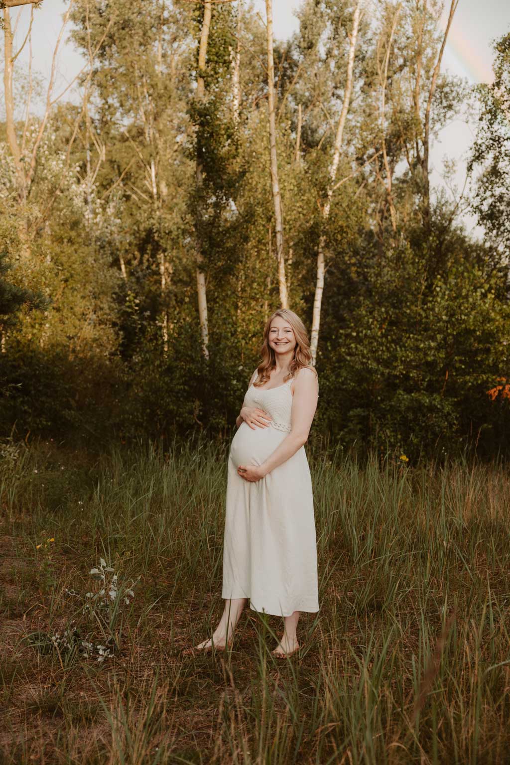 Babybauchfotos in berlin mit der Berliner Fotografin für Kinderfotografie Maria Brussig Lensofbeauty. fotos am See. Fotoshooting Babybauch im grünen. Wasser im Hintergrund. Paarfotos zusammen am See.