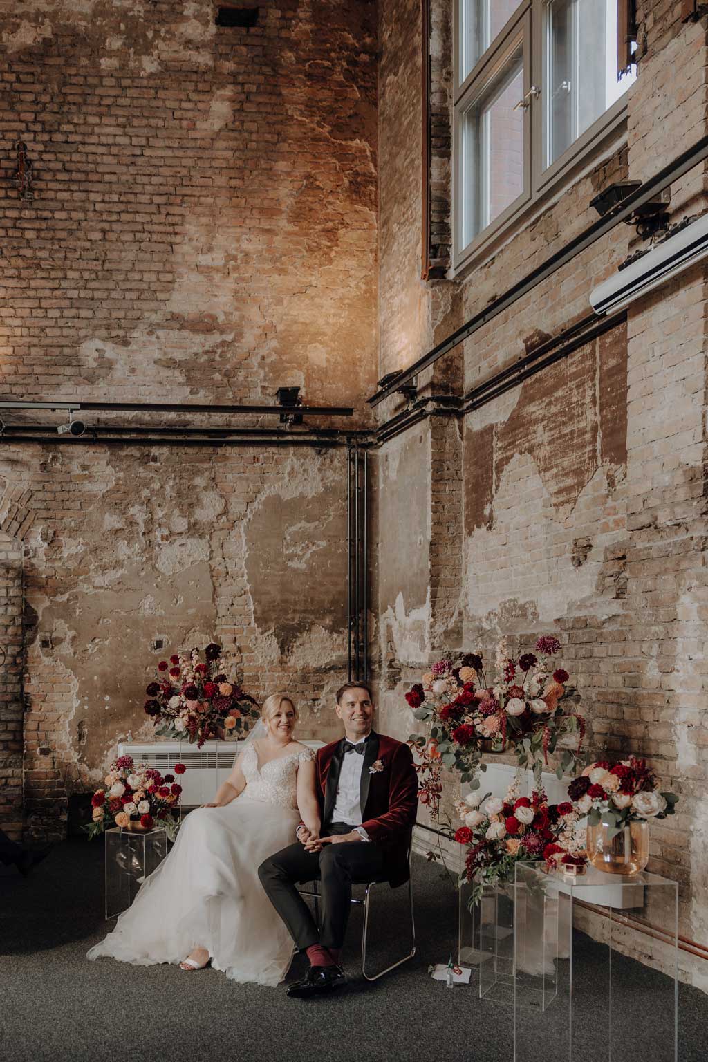 trauung Inder charité in der hoersaalruine mit mir als hochzeitsfotograf und roten tollen Blumen in berlin in einer tollen hochzeitsloaction