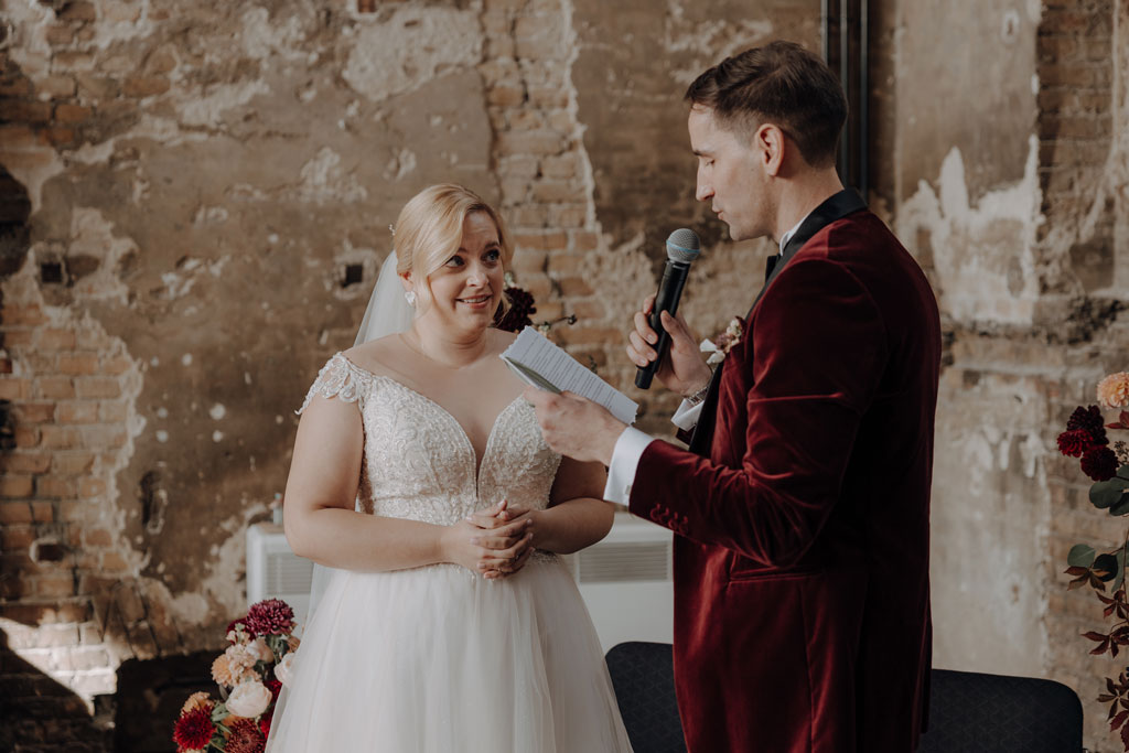 trauung Inder charité in der hoersaalruine mit mir als hochzeitsfotograf und roten tollen Blumen in berlin in einer tollen hochzeitsloaction