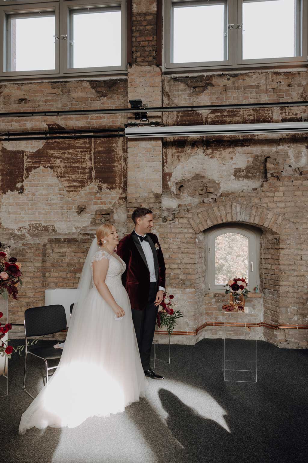 trauung Inder charité in der hoersaalruine mit mir als hochzeitsfotograf und roten tollen Blumen in berlin in einer tollen hochzeitsloaction