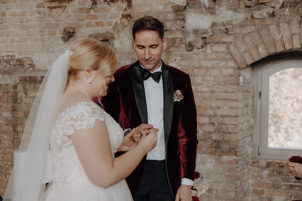 trauung Inder charité in der hoersaalruine mit mir als hochzeitsfotograf und roten tollen Blumen in berlin in einer tollen hochzeitsloaction