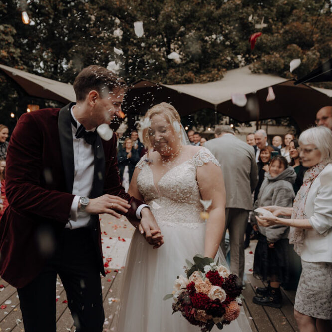 Hochzeitsfeier in der alten Turnhalle in berlin Friedrichshain mit dj jung aus berlin. Hochzeitsparty Hochzeitsfeier mit mir als Fotografin als hochzeitsfotograf. reis und Rosen werden gescmissen beim Spalier vor der alten Turnhalle