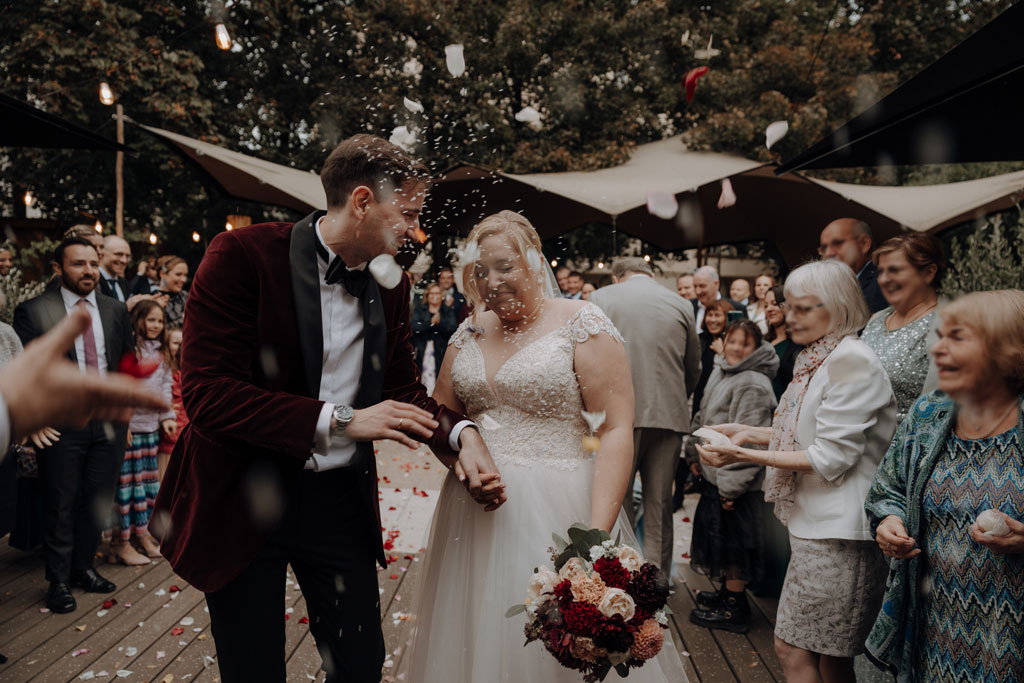 Hochzeitsfeier in der alten Turnhalle in berlin Friedrichshain mit dj jung aus berlin. Hochzeitsparty Hochzeitsfeier mit mir als Fotografin als hochzeitsfotograf. reis und Rosen werden gescmissen beim Spalier vor der alten Turnhalle