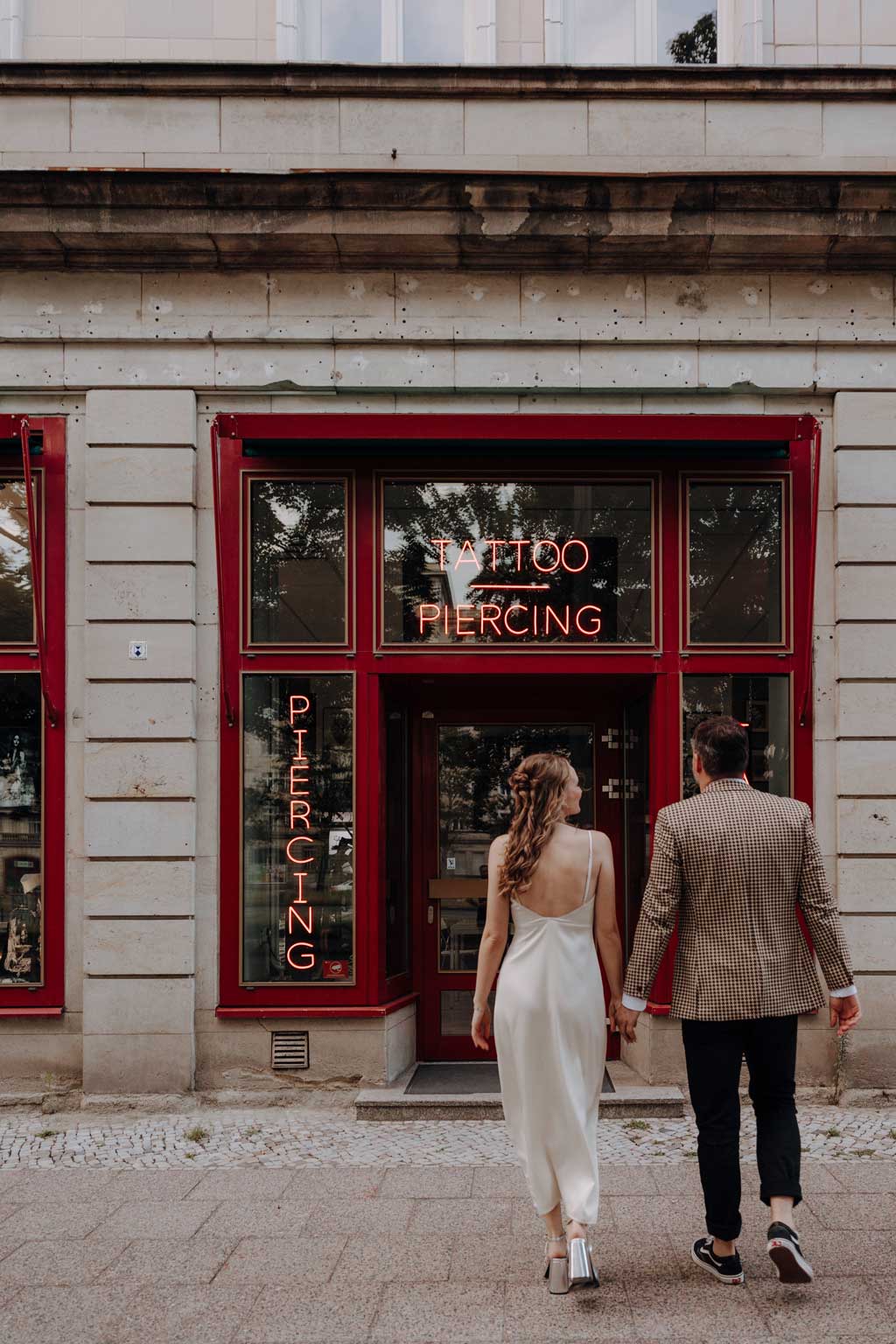 Hochzeit in berlin an der Frankfurter Allee mit Fernsehturm im Hintergrund und Tattoo und Piercing studio. Eheringe auf pizza. Paarfotos in berlin. Hochzeit mitten in berlin. außergewöhnliche Festival rock Hochzeit. Festival Hochzeit. rock Hochzeit.