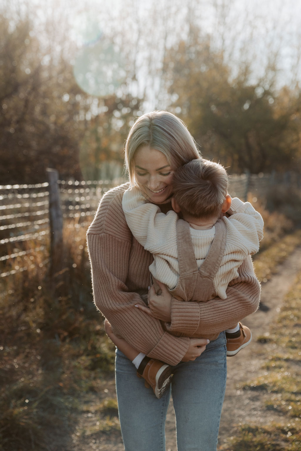 familienfotos familienfotografie kindefotos in Berlin Karlshorst in der Natur mit mama und Sohn. familienfotoshooting zu zweit im freuen mit Schafen auf einem Feld.