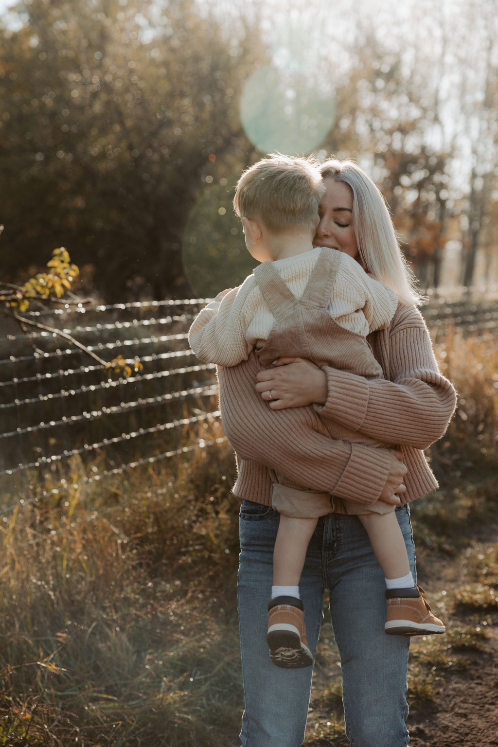 familienfotos familienfotografie kindefotos in Berlin Karlshorst in der Natur mit mama und Sohn. familienfotoshooting zu zweit im freuen mit Schafen auf einem Feld.