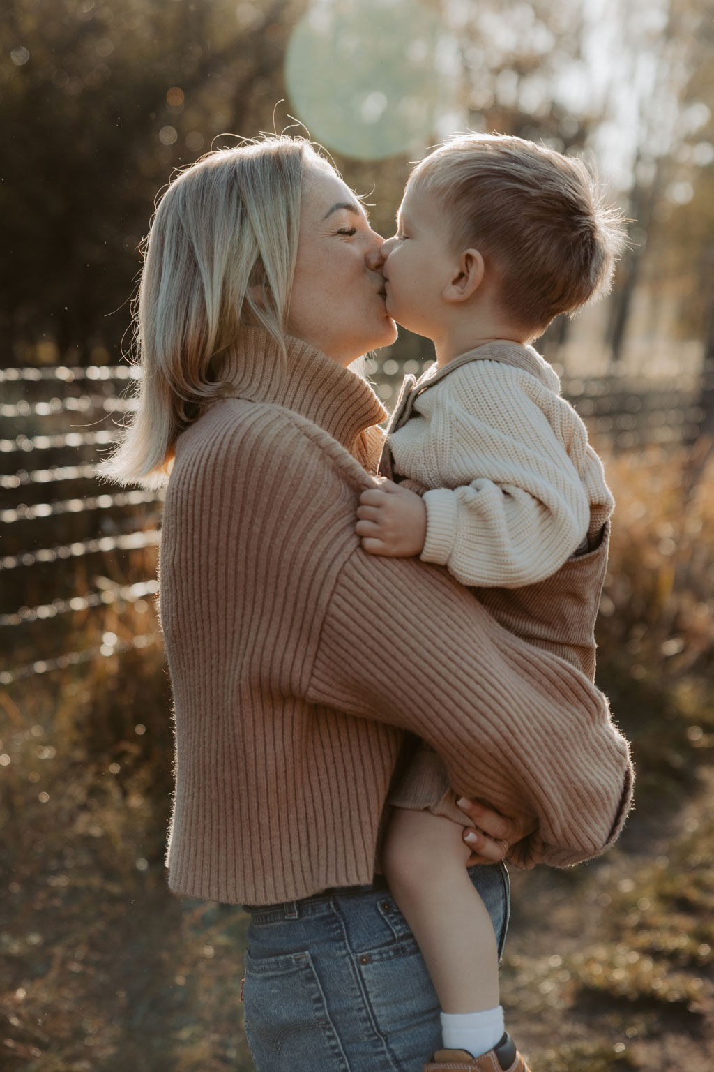 familienfotos familienfotografie kindefotos in Berlin Karlshorst in der Natur mit mama und Sohn. familienfotoshooting zu zweit im freuen mit Schafen auf einem Feld.