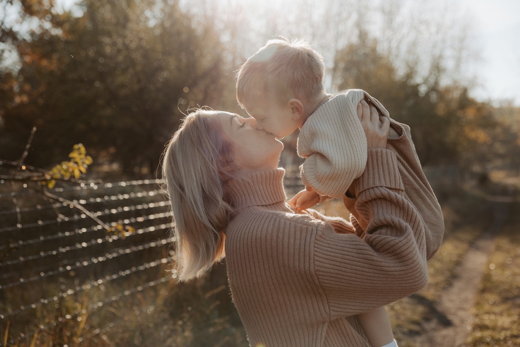 familienfotos familienfotografie kindefotos in Berlin Karlshorst in der Natur mit mama und Sohn. familienfotoshooting zu zweit im freuen mit Schafen auf einem Feld.