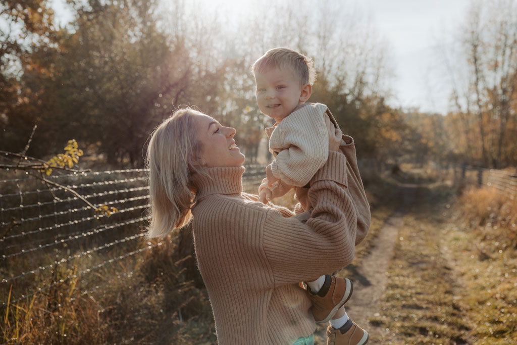 familienfotos familienfotografie kindefotos in Berlin Karlshorst in der Natur mit mama und Sohn. familienfotoshooting zu zweit im freuen mit Schafen auf einem Feld.