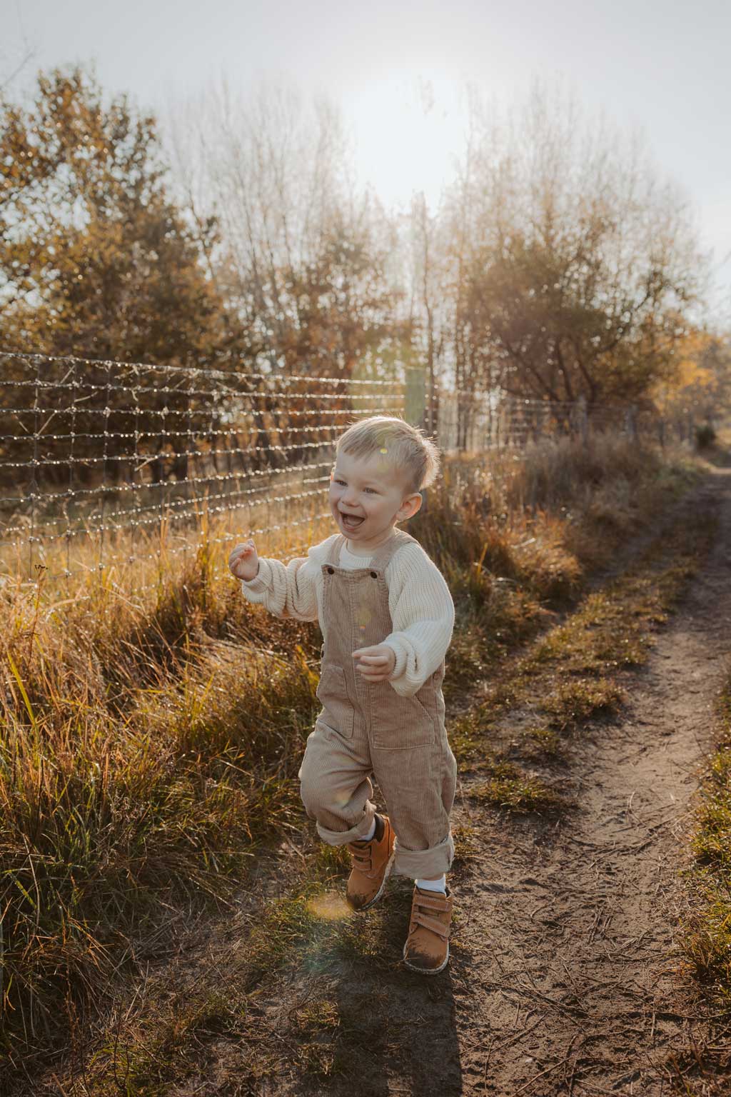 familienfotos familienfotografie kindefotos in Berlin Karlshorst in der Natur mit mama und Sohn. familienfotoshooting zu zweit im freuen mit Schafen auf einem Feld.