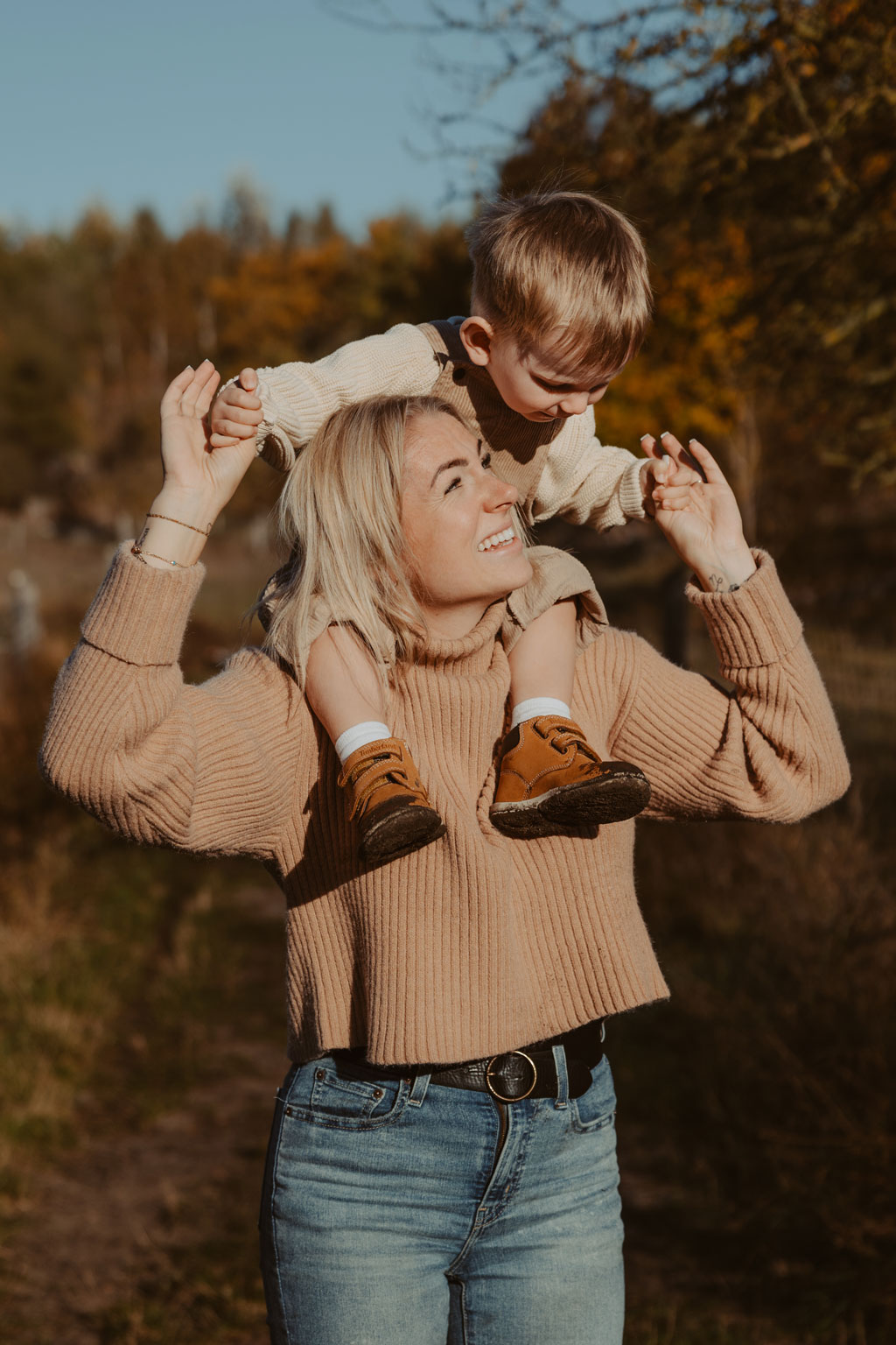 familienfotos familienfotografie kindefotos in Berlin Karlshorst in der Natur mit mama und Sohn. familienfotoshooting zu zweit im freuen mit Schafen auf einem Feld.