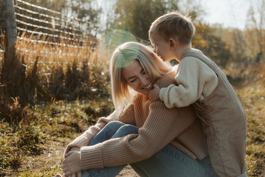 familienfotos familienfotografie kindefotos in Berlin Karlshorst in der Natur mit mama und Sohn. familienfotoshooting zu zweit im freuen mit Schafen auf einem Feld.