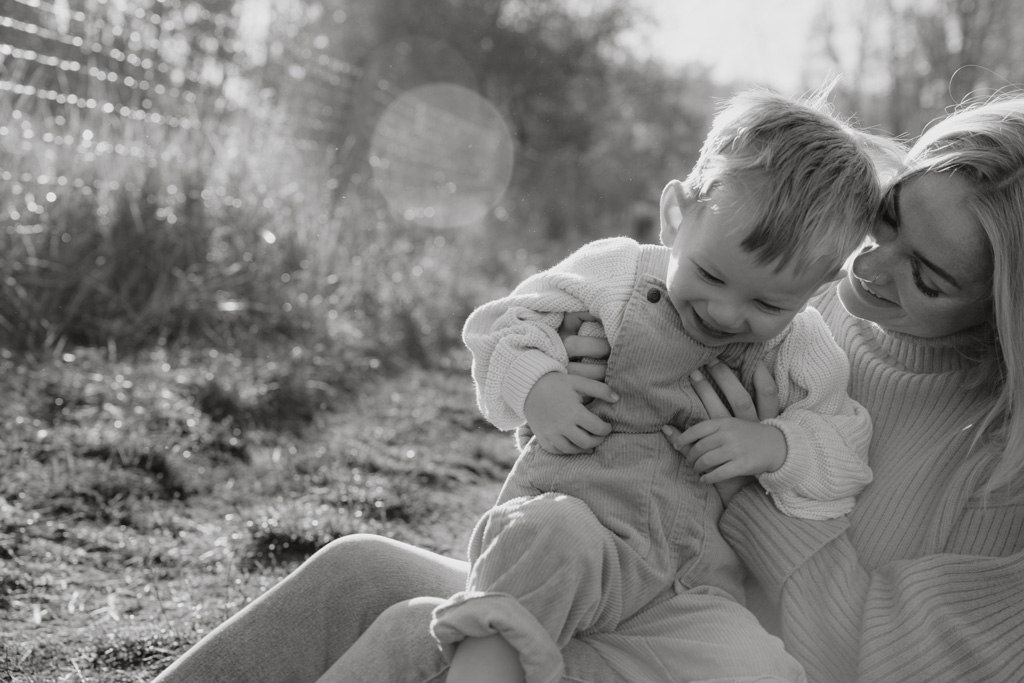 familienfotos familienfotografie kindefotos in Berlin Karlshorst in der Natur mit mama und Sohn. familienfotoshooting zu zweit im freuen mit Schafen auf einem Feld.