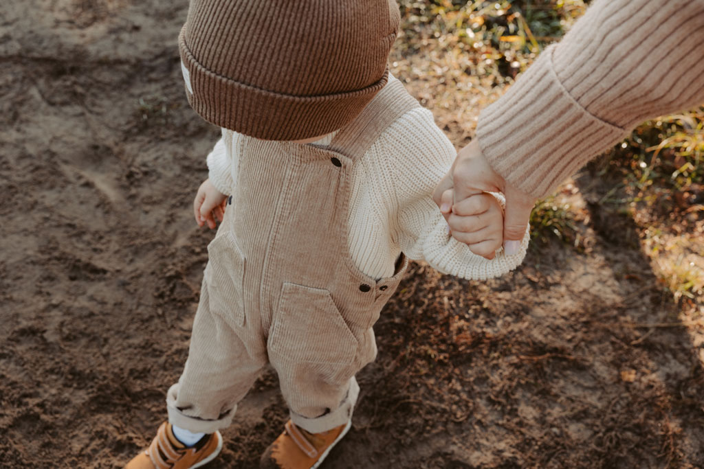 familienfotos familienfotografie kindefotos in Berlin Karlshorst in der Natur mit mama und Sohn. familienfotoshooting zu zweit im freuen mit Schafen auf einem Feld.